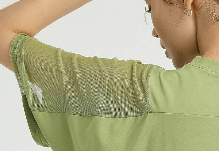 Close-up of a woman wearing a green loose running mesh short sleeves t-shirt. Ideal for women's workout sports clothing. SF0044
